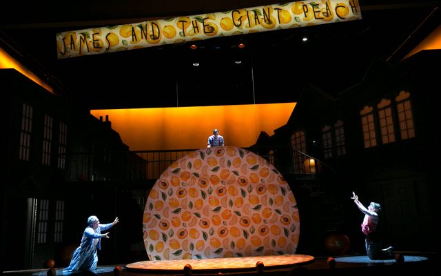 James and the Giant Peach ensemble on stage watch a giant peach rise up from the stage.
